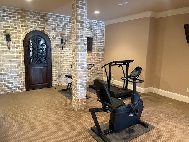 889 Plantation Blvd, Gallatin, TN 37066 - workout room featuring carpet floors, brick wall, baseboards, and ornamental molding