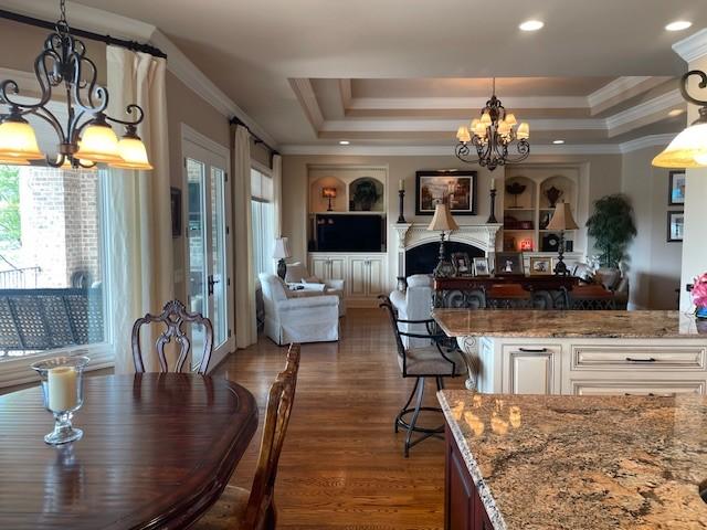 889 Plantation Blvd, Gallatin, TN 37066 - dining space featuring recessed lighting, a raised ceiling, wood finished floors, crown molding, and a notable chandelier