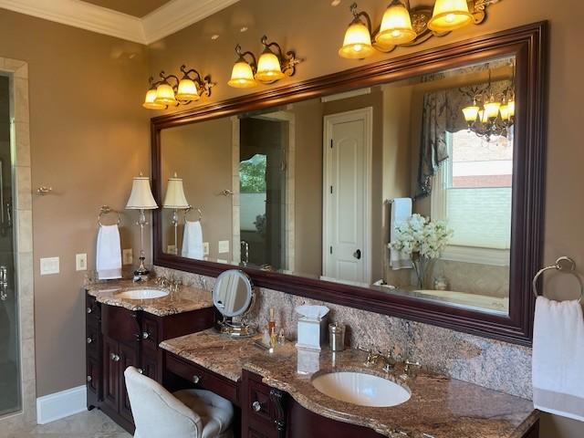889 Plantation Blvd, Gallatin, TN 37066 - bathroom featuring a stall shower, baseboards, a notable chandelier, vanity, and ornamental molding