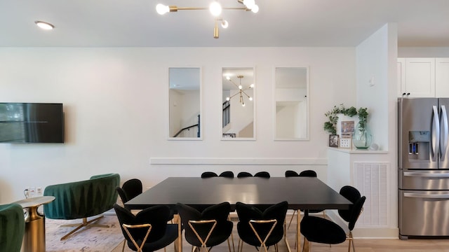 dining area with an inviting chandelier, light wood-style floors, and visible vents