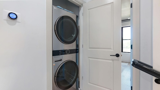 clothes washing area with stacked washer / dryer and laundry area