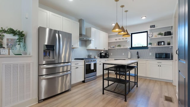 kitchen featuring wall chimney range hood, open shelves, a sink, stainless steel appliances, and light countertops