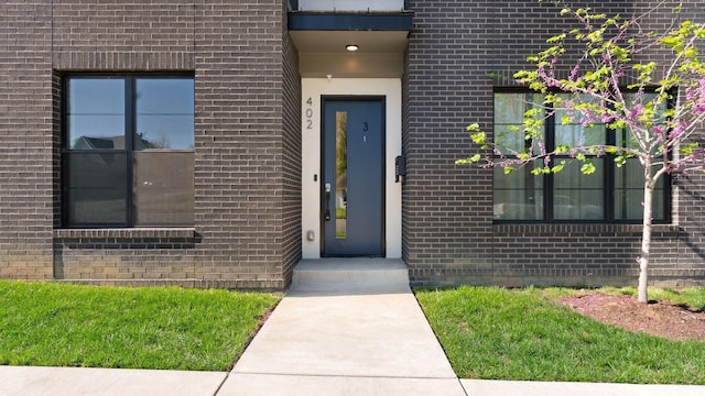 doorway to property with brick siding