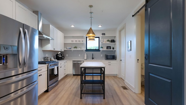 kitchen featuring wall chimney exhaust hood, light wood-type flooring, visible vents, open shelves, and appliances with stainless steel finishes