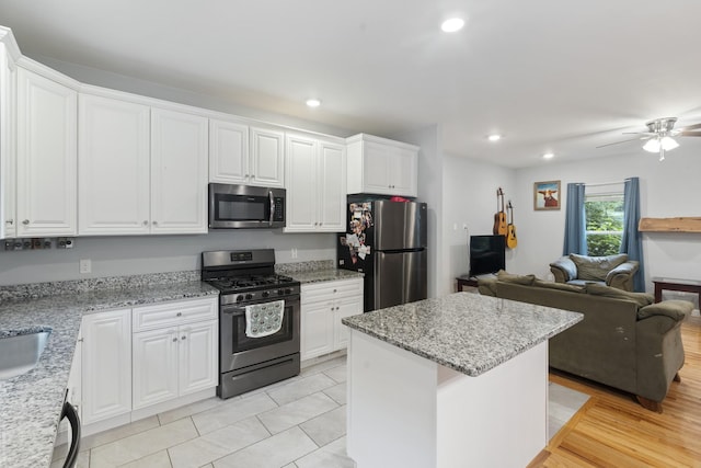 6336 Hickory Dr, Centerville, TN 37033 - kitchen with appliances with stainless steel finishes, light stone counters, a center island, open floor plan, and white cabinets