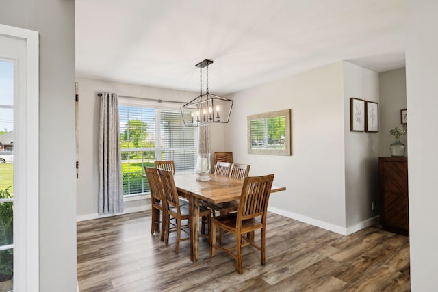 dining area featuring baseboards, wood finished floors, and a chandelier