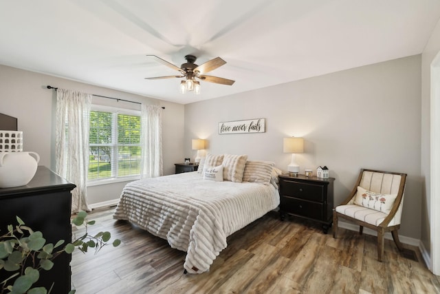 bedroom featuring baseboards, a ceiling fan, and wood finished floors