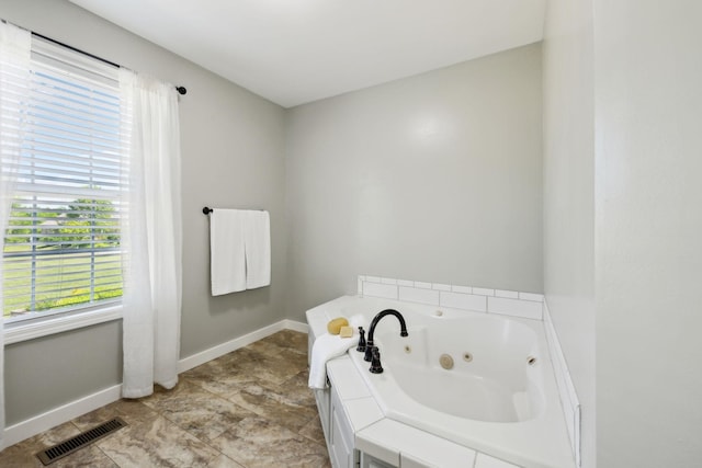 full bathroom featuring visible vents, baseboards, and a jetted tub