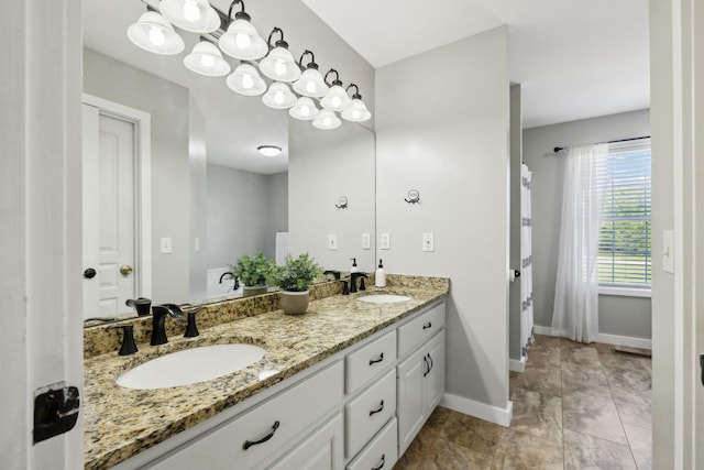 bathroom with a sink, baseboards, and double vanity