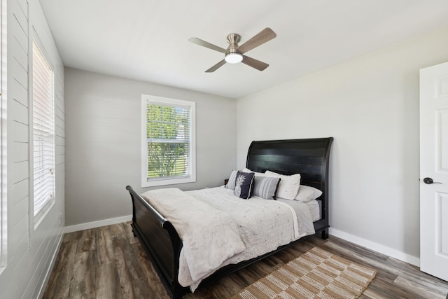 bedroom with dark wood-type flooring, a ceiling fan, and baseboards