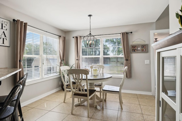dining space featuring baseboards, an inviting chandelier, and light tile patterned floors