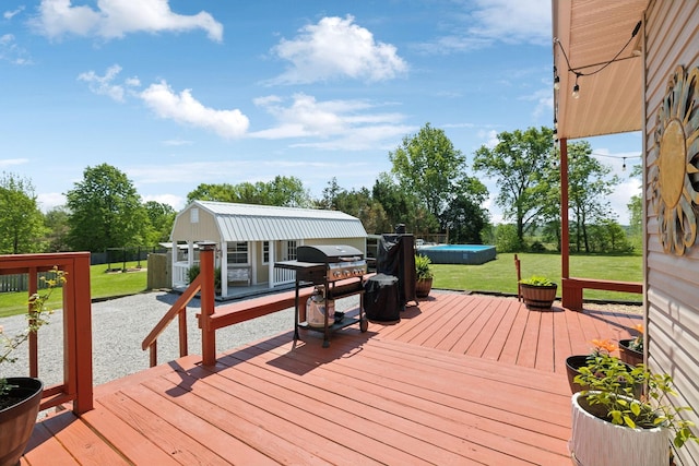 wooden terrace with a lawn, an outdoor structure, and an outdoor pool