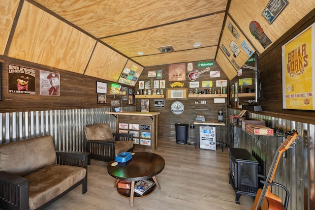 interior space with wood walls, wood finished floors, and a wood stove