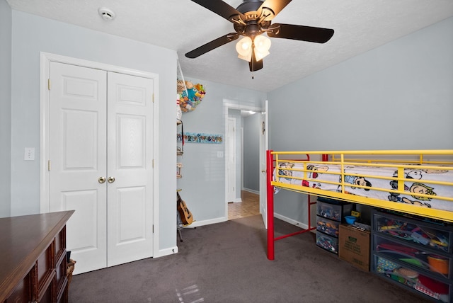 carpeted bedroom featuring a closet, baseboards, and ceiling fan
