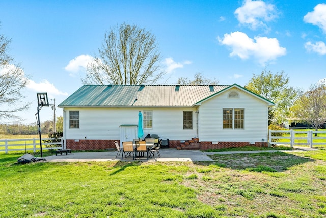 back of property with a lawn, fence, a patio, and crawl space
