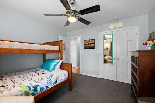 bedroom featuring dark carpet, a closet, a ceiling fan, and baseboards