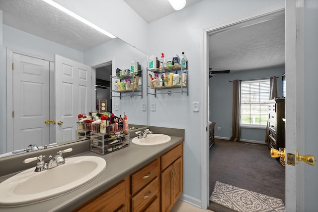 bathroom with a textured ceiling, baseboards, and a sink