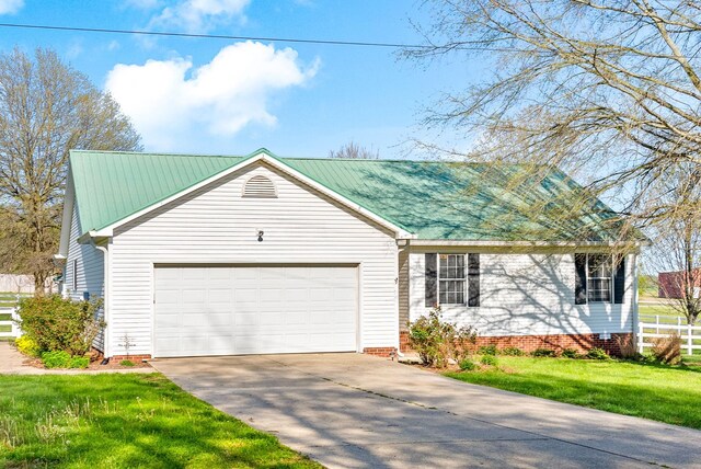 ranch-style house with an attached garage, driveway, fence, and a front yard