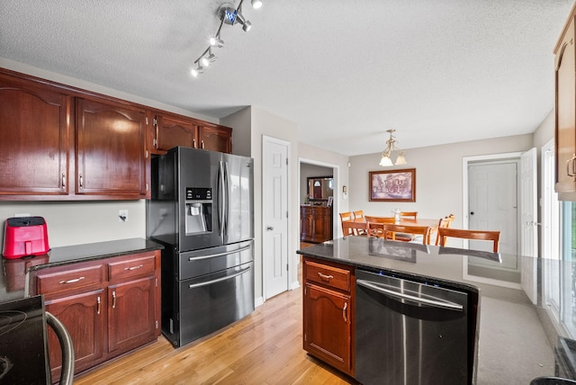 2413 Tana Way, Clarksville, TN 37042 - kitchen featuring dark countertops, a textured ceiling, light wood-style floors, and appliances with stainless steel finishes