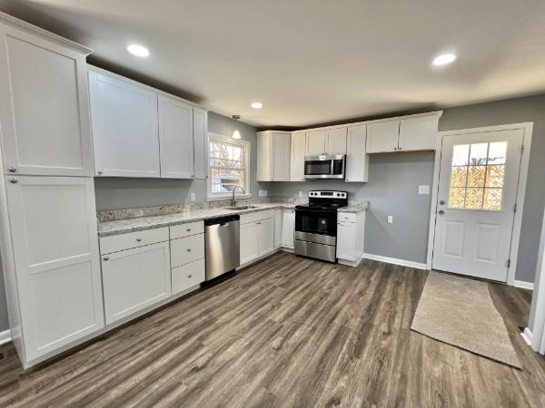 210 Ragan St, Tullahoma, TN 37388 - kitchen with a sink, stainless steel appliances, white cabinets, baseboards, and dark wood-style floors