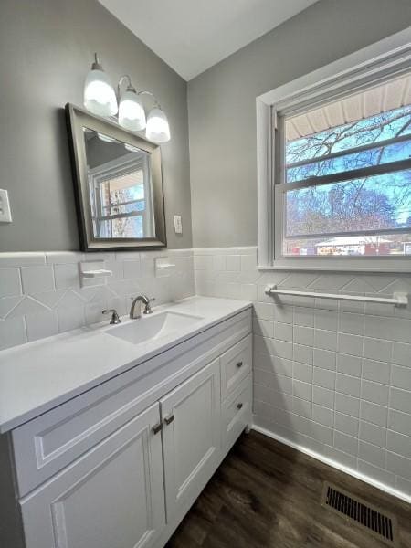 210 Ragan St, Tullahoma, TN 37388 - bathroom with wainscoting, tile walls, visible vents, wood finished floors, and vanity