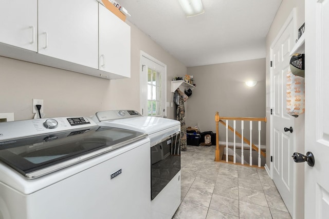 laundry room featuring cabinet space, marble finish floor, and washer and clothes dryer