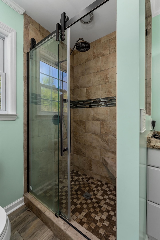full bath with a shower stall, toilet, and wood finished floors