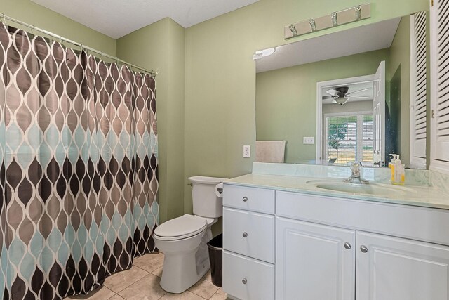 bathroom featuring toilet, tile patterned flooring, a shower with shower curtain, ceiling fan, and vanity