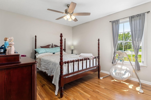 bedroom featuring light wood-style flooring, baseboards, and ceiling fan