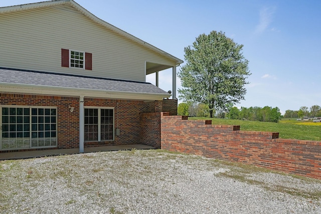 view of property exterior with a shingled roof