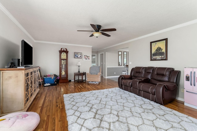 living room with a textured ceiling, baseboards, a ceiling fan, wood finished floors, and crown molding