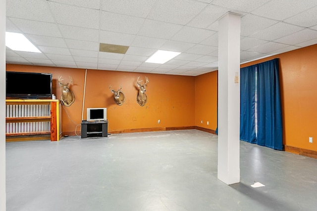 finished below grade area with a paneled ceiling and baseboards