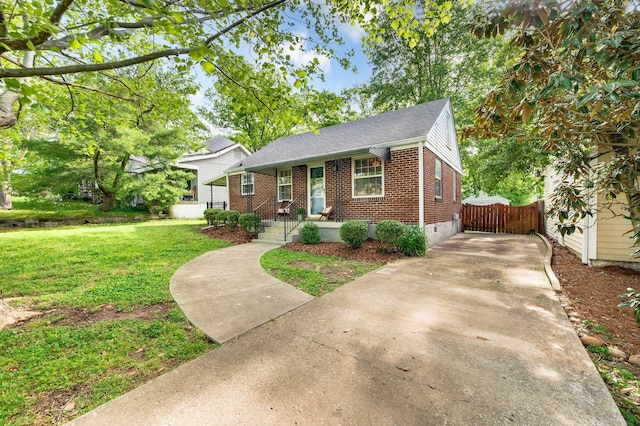 120 39th Ave N, Nashville, TN 37209 - view of front facade featuring a front lawn, driveway, fence, brick siding, and a shingled roof