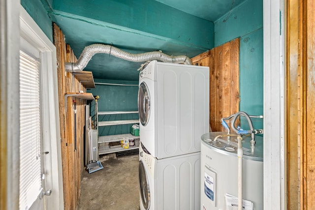 laundry room featuring stacked washer / dryer and electric water heater