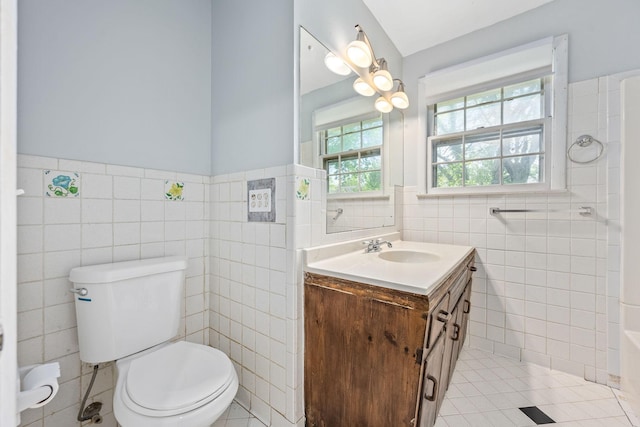 bathroom with tile walls, tile patterned floors, wainscoting, and toilet