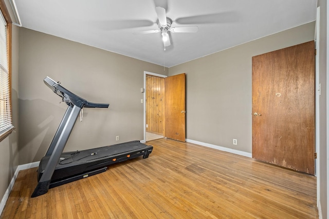 exercise room with wood finished floors, baseboards, and ceiling fan