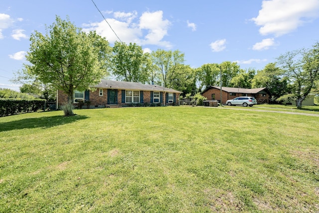 ranch-style home featuring brick siding and a front yard