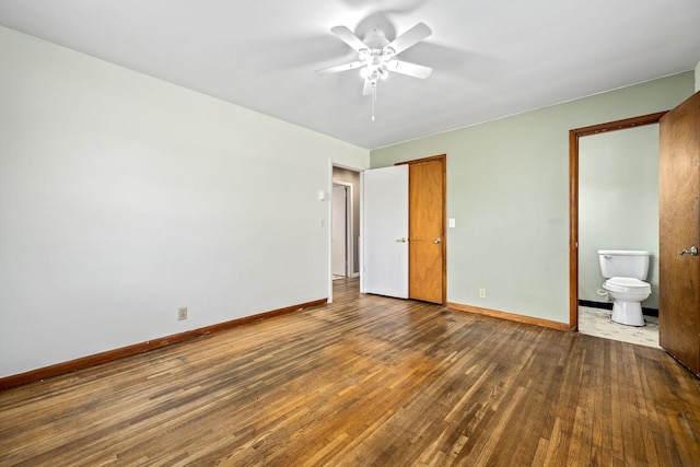 unfurnished bedroom with baseboards, ensuite bath, wood finished floors, and a ceiling fan