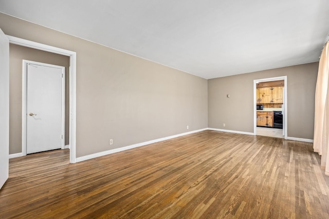 unfurnished living room featuring baseboards and wood finished floors