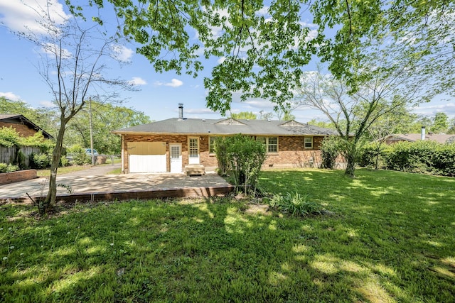view of front of home with fence, brick siding, a front yard, and a patio