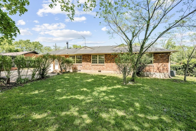 back of property with brick siding, central air condition unit, and a lawn