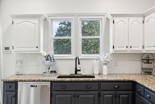 kitchen featuring a sink, white cabinetry, dishwasher, and tasteful backsplash