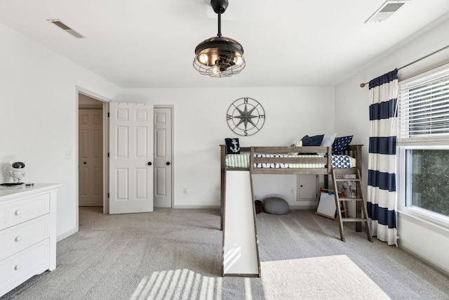 bedroom with multiple windows, light carpet, and visible vents