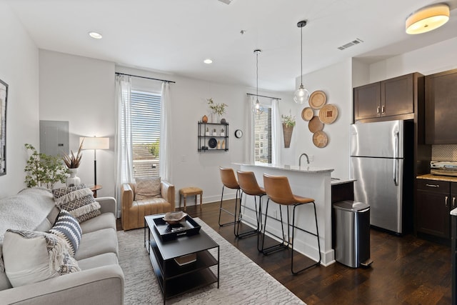 living room with dark wood-type flooring, visible vents, and recessed lighting