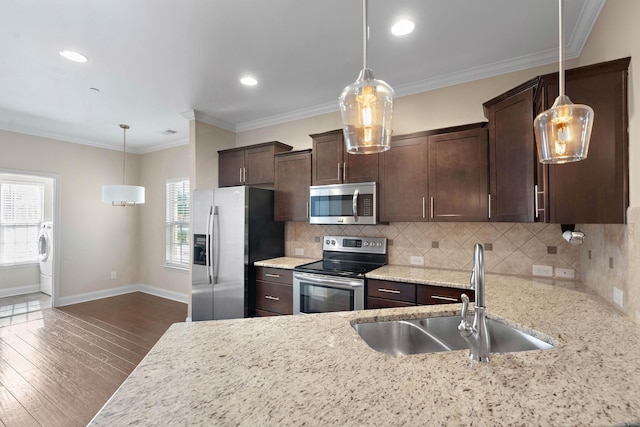 kitchen featuring a sink, dark wood-style flooring, dark brown cabinets, washer / clothes dryer, and appliances with stainless steel finishes