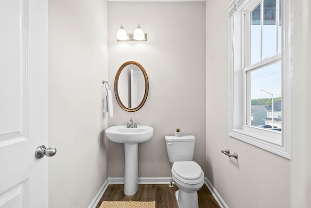 bathroom with wood finished floors, toilet, and baseboards
