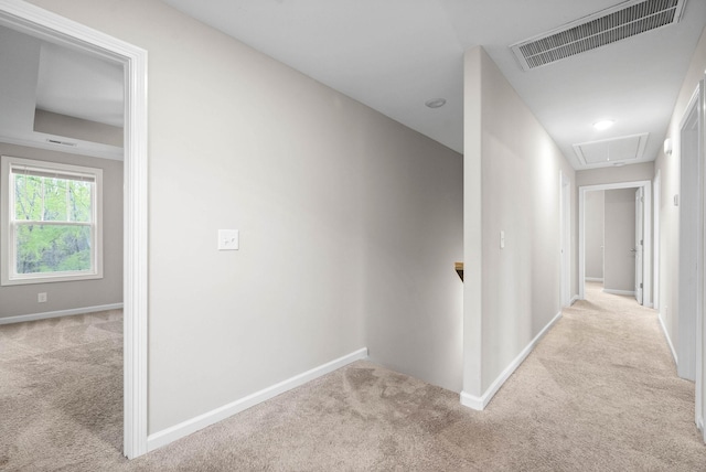 hall featuring attic access, carpet floors, visible vents, and baseboards
