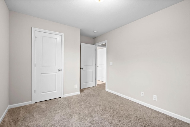 unfurnished bedroom featuring carpet flooring and baseboards