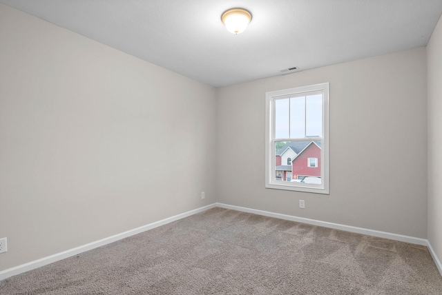carpeted empty room with visible vents and baseboards