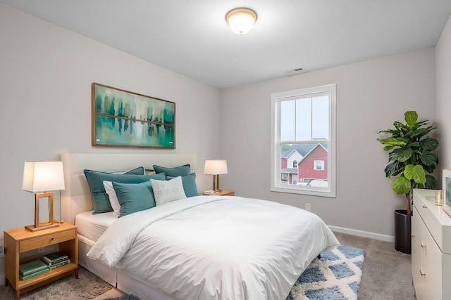 bedroom with light colored carpet, baseboards, and visible vents